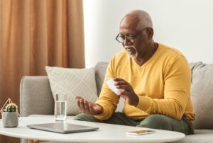 Homem toma comprimido, garantindo adesão ao tratamento medicamentoso